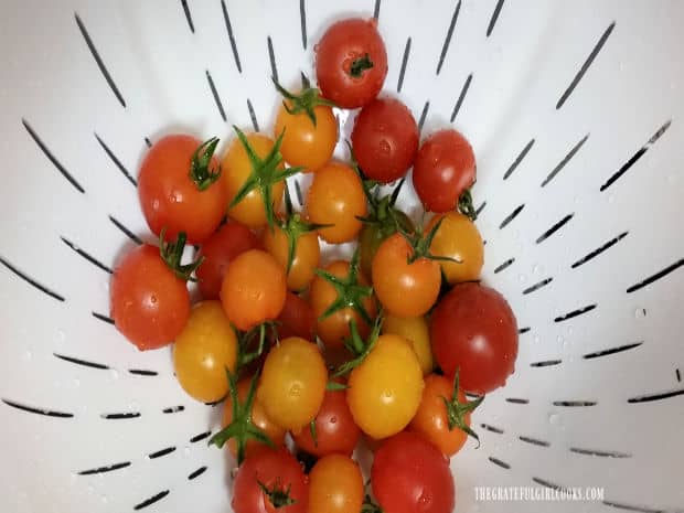 Cherry tomatoes are rinsed, then stems are removed.