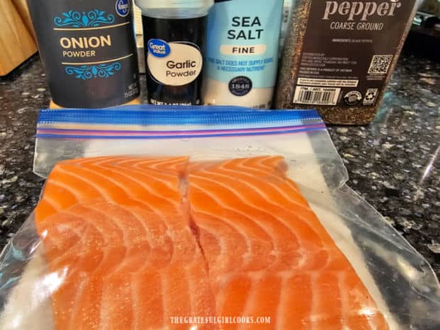 Two salmon fillets along with spices used when cooking the fish.