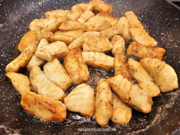 Boiled gnocchi are combined in a skillet with brown butter sage sauce and reheated.