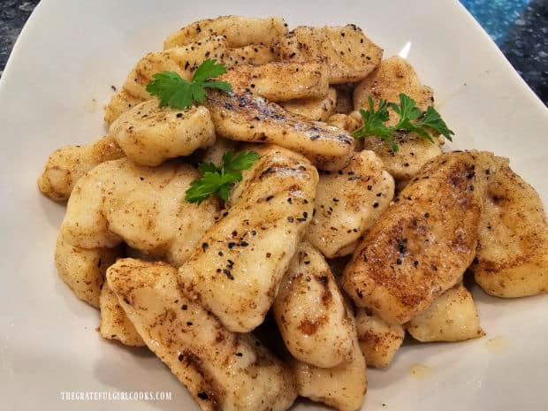 Homemade potato gnocchi is garnished with fresh parsley and served hot.