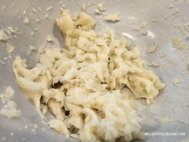 The cooked potato is peeled and then mashed until smooth.