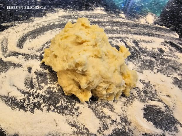 the dough for gnocchi is turned out onto a flour-covered surface.