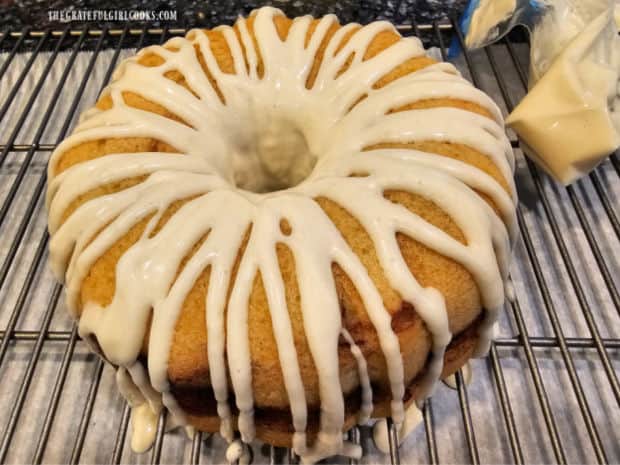 Sweet cream cheese icing is used to drizzle over the surface of the warm bundt cake.