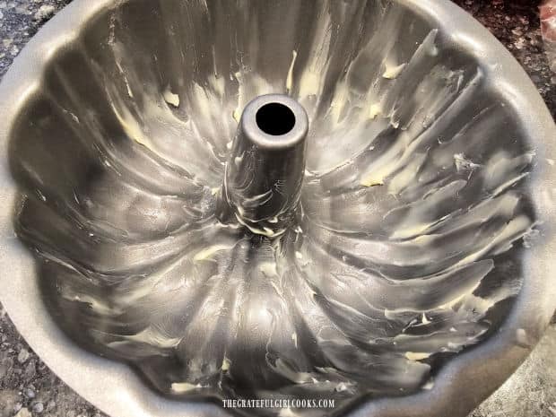 A 1-quart bundt pan is generously coated with butter before filling with batter.