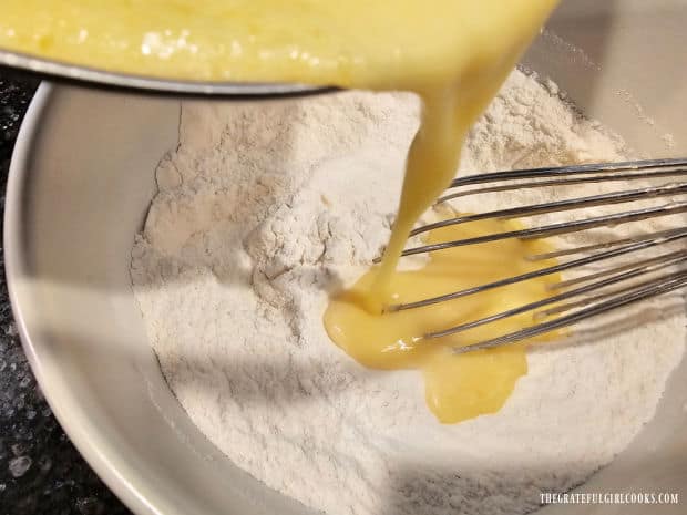 Wet ingredients are poured into and mixed with the dry ingredients until combined.