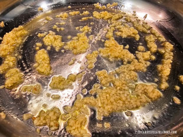 Minced garlic cooks in warm olive oil until fragrant.