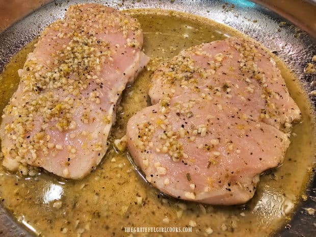 The lemon garlic sauce is spooned over the top of the chicken before baking.