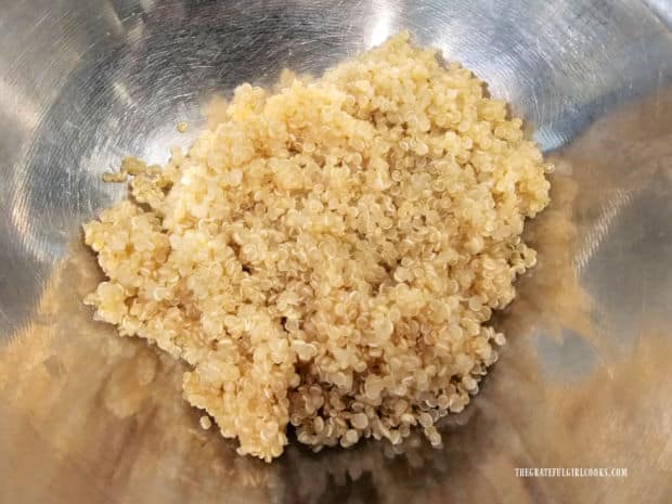 The cooked quinoa is cooled to room temperature in a bowl.