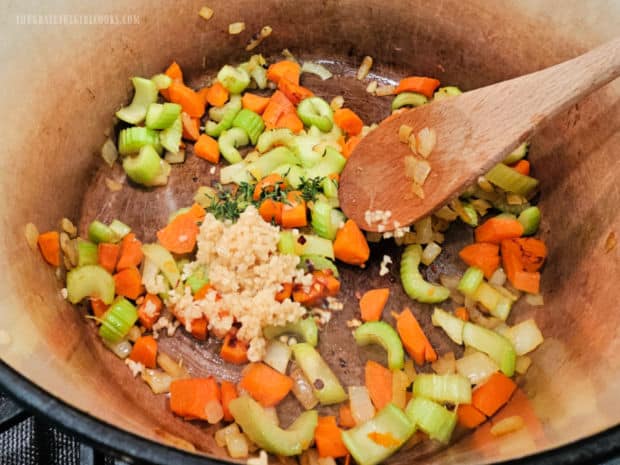 Veggies, plus garlic and herbs are cooked in olive oil in a large soup pot.