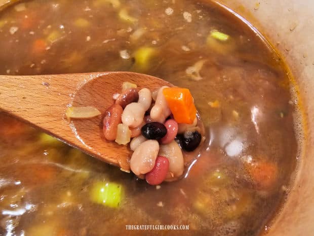 A spoonful of the bean and kale soup before the kale is added.
