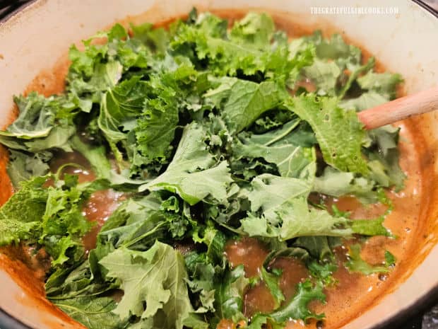 Small pieces of kale and lemon juice are added to the bean and kale soup.