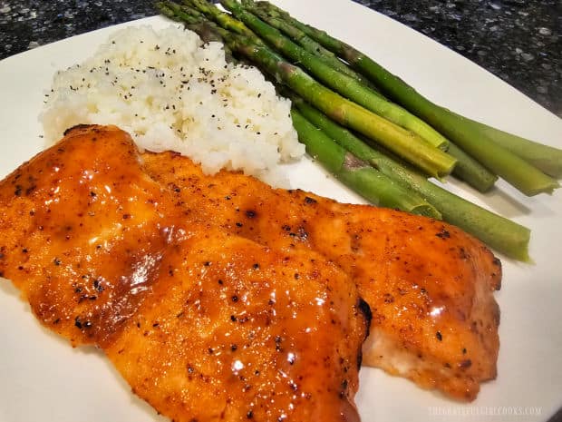 Asparagus and white rice, served on a white plate with broiled honey Dijon salmon.