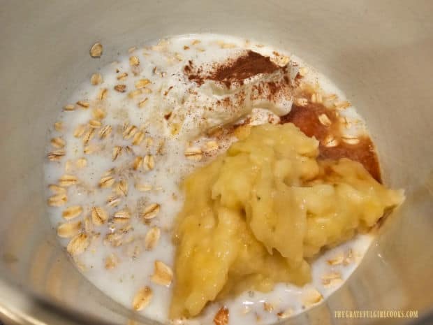 Oats, milk, yogurt, maple syrup, mashed banana, vanilla and cinnamon in a bowl.