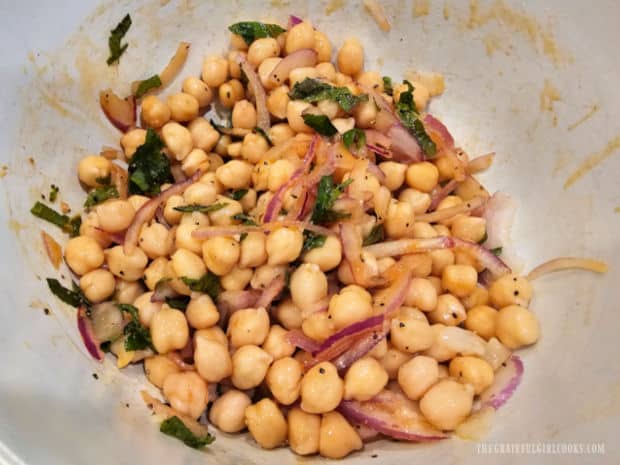 The garbanzo salad is tossed with homemade salad dressing until combined.