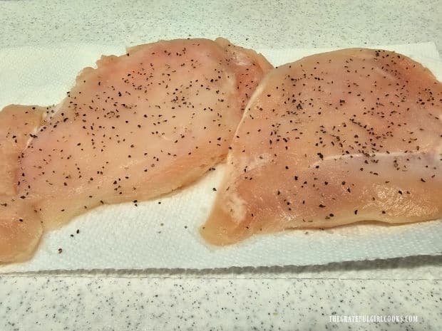 Chicken is flattened and then seasoned with ground pepper and salt.