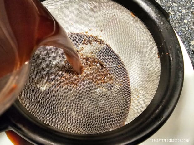 Thai Iced Coffee - The Grateful Girl Cooks! Pouring the coffee mixture through a wire mesh strainer into a large bowl.