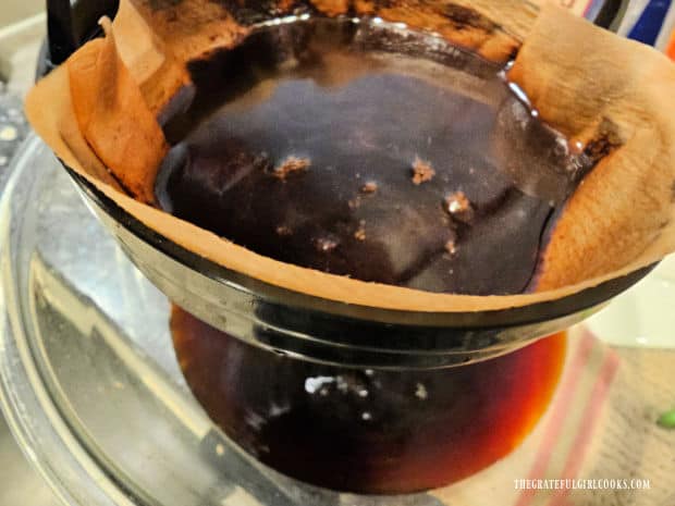 Thai Iced Coffee - The Grateful Girl Cooks! Coffee filter in a strainer catches the remaining grounds and coffee drips through.