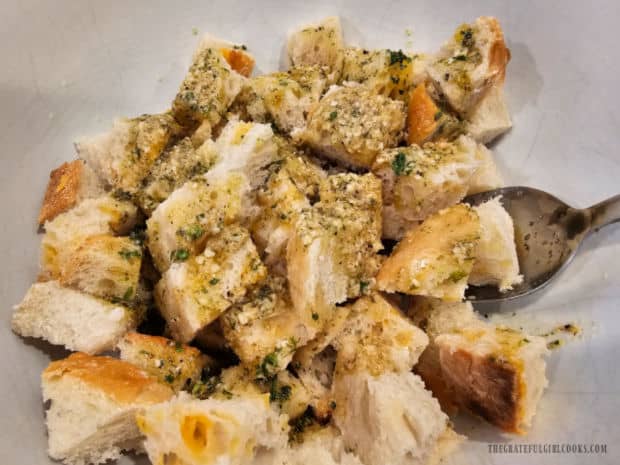 The seasoning mix is poured over bread cubes and tossed well to combine.