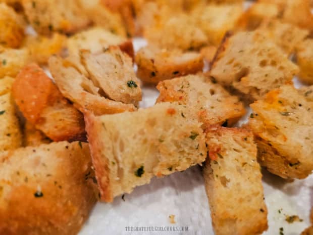 A closeup photo of well-seasoned, crispy air fryer salad croutons, ready to use.