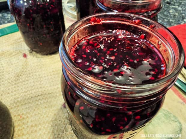 Jars are filled with hot marionberry jam before adding them to the canner.