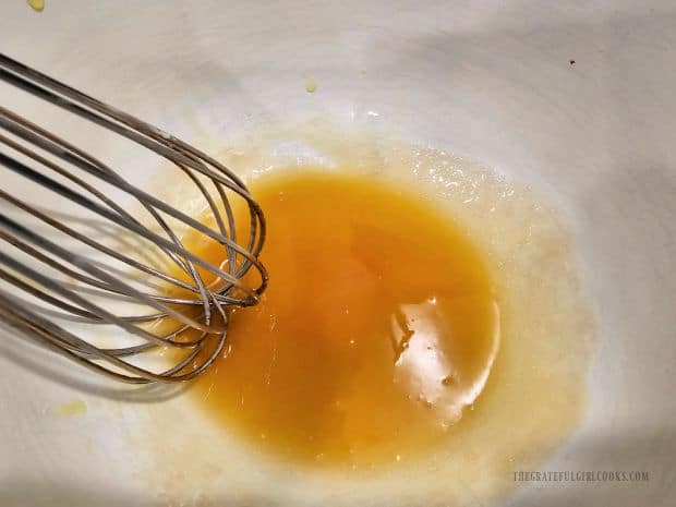 Salad dressing is whisked until the oil and vinegar become emulsified.