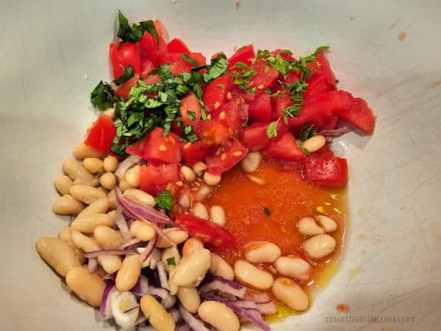 Cannellini beans, tomatoes, onion and fresh basil and oregano added to salad dressing.