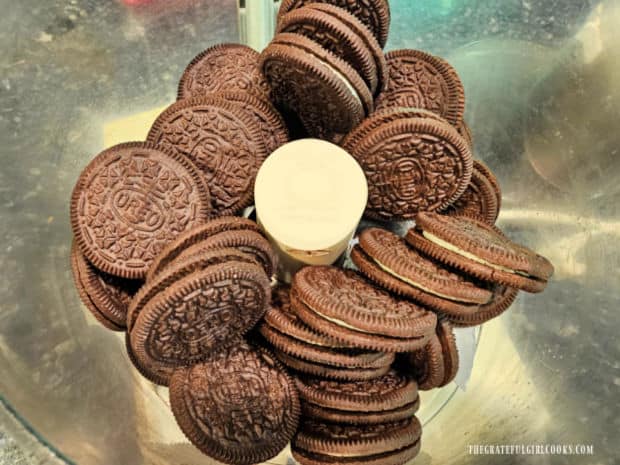 Chocolate creme-filled cookies are processed in a food processor until they become crumbs.