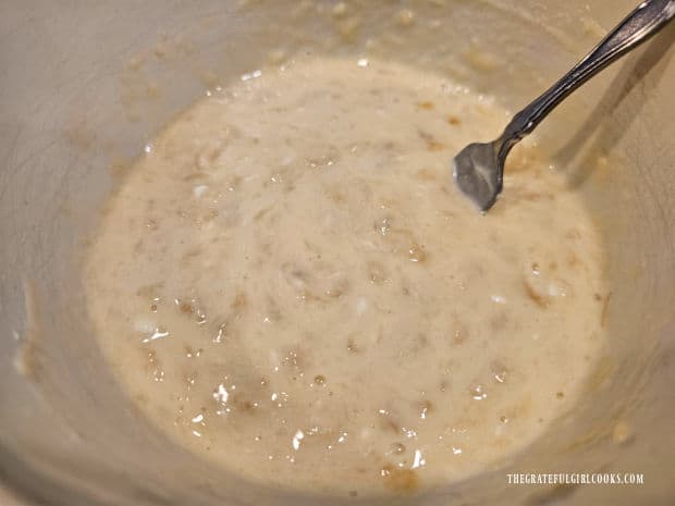 Air Fryer Banana Pecan Cake - The Grateful Girl Cooks! A bowl of mixed bananas, sour cream, egg and oil is ready for remaining ingredients.