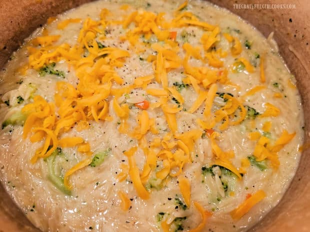 Salt, pepper and more grated cheddar are added to the broccoli cheese orzo.
