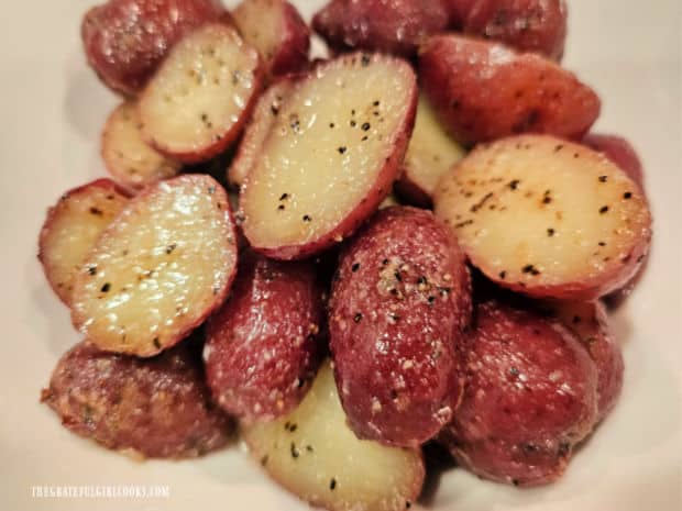 Potatoes are transferred from pan to bowl, and any remaining garlic butter is poured on top.