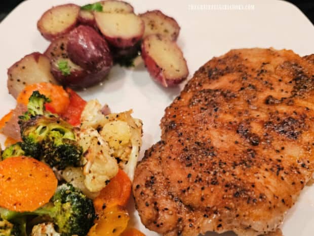 Garlic butter red potatoes served along with veggies and a pork chop.