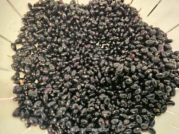 Black beans are rinsed well and then drained in a colander before cooking.