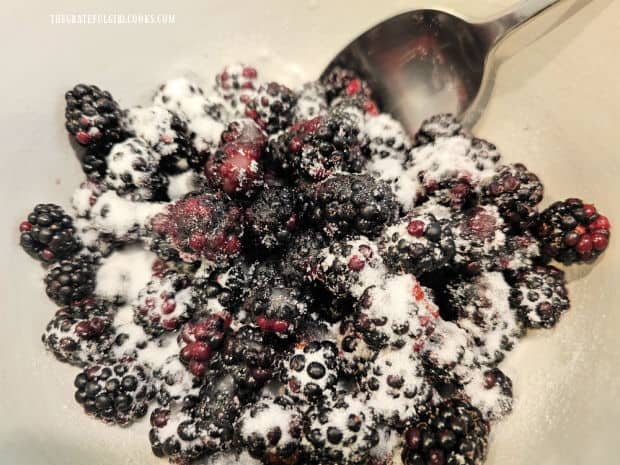 Blackberries are stirred and covered with sugar and lemon juice.