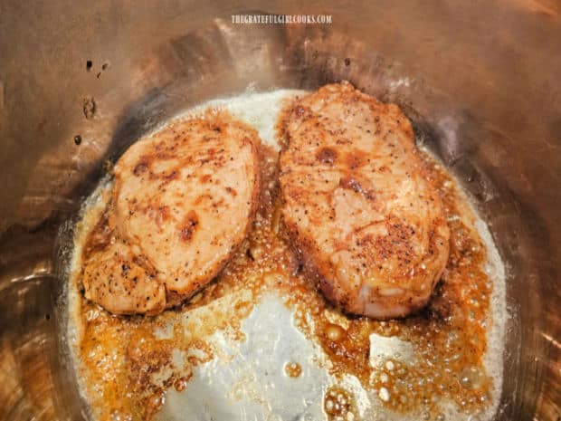 Both sides of the seasoned pork chops are lightly browned in the Instant Pot.