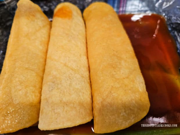 Air Fryer Cheese Enchiladas - The Grateful Girl Cooks! Enchiladas are placed, seam side down, on top of sauce in baking dish.