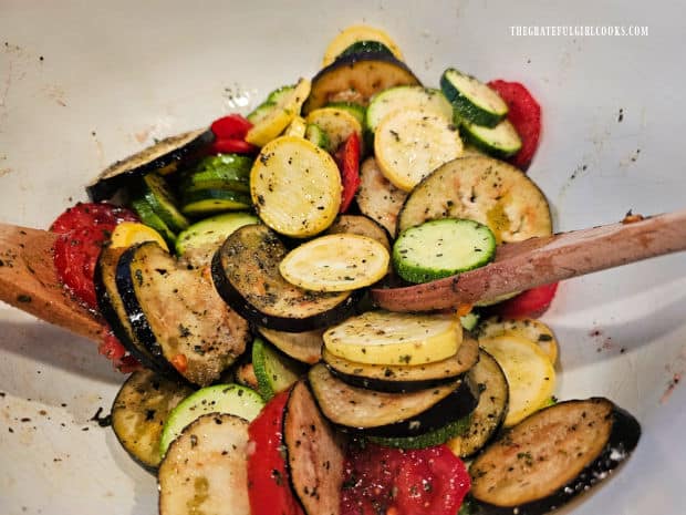 Vegetables for the ratatouille are gently tossed with oil and spices until coated.
