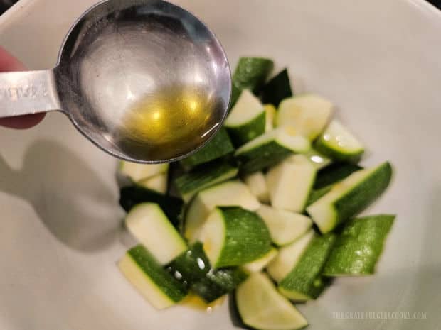 Air Fryer Zucchini Bites (For Two) - The Grateful Girl Cooks! Olive oil is drizzled over the zucchini, then tossed to combine and coat the veggies.