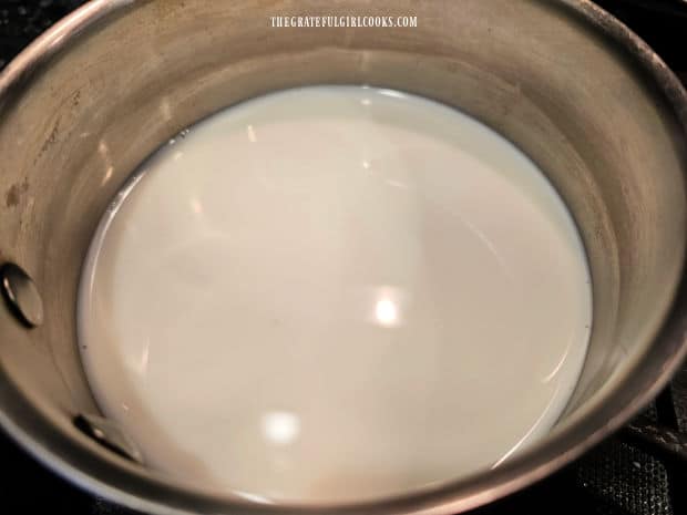 Classic Hot Cocoa For 1 - The Grateful Girl Cooks! A cup of milk is heated on Low heat in a pan on the stove.