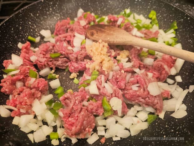 Garlic is added and the meat is browned and broken up into pieces as it cooks.