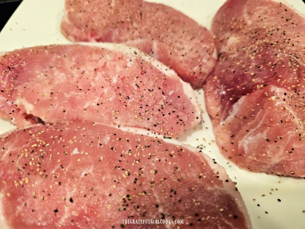 Four boneless pork chops, seasoned with salt and pepper.