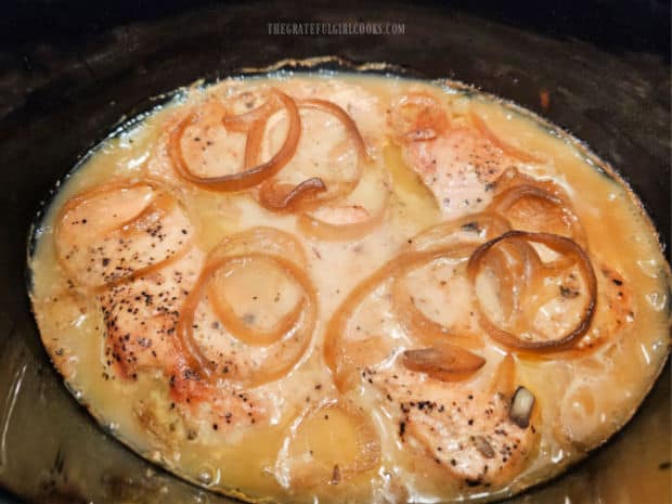 After slow-cooking 6 hours, onions are browned, and gravy surrounds the tender pork chops.