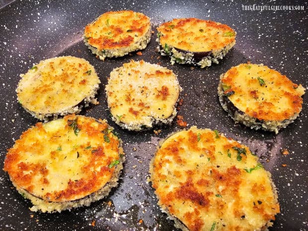 After a few minutes, crispy eggplant Milanese slices are turned to cook the other side.