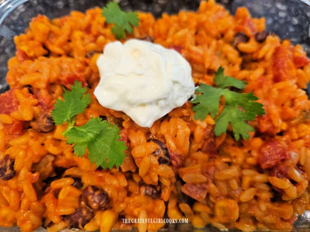Crockpot Cheesy Enchilada Orzo - The Grateful Girl Cooks! The crockpot cheesy enchilada orzo, garnished with cilantro and sour cream for serving.