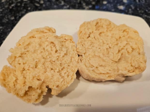A biscuit made with the homemade baking mix, cut in half on a white plate.