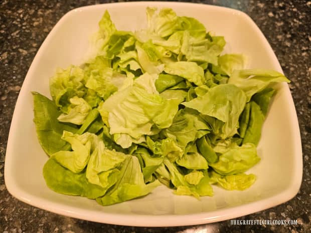 Kimberly's Festive Salad - The Grateful Girl Cooks! Chilled butter lettuce is torn into pieces and placed in a large serving bowl.