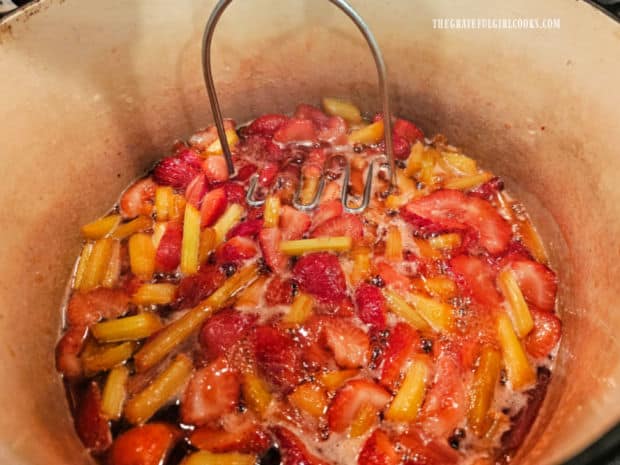 A potato masher is used to help break down the fruit as it cooks.