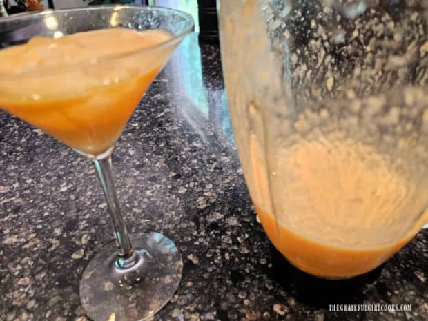 Blended peach and lemonade mixture is poured into ice-filled glass.