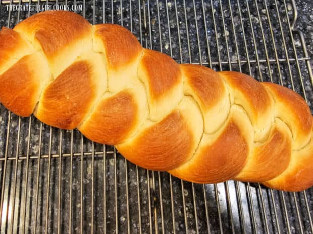 After baking, the classic challah bread cools on a wire rack.