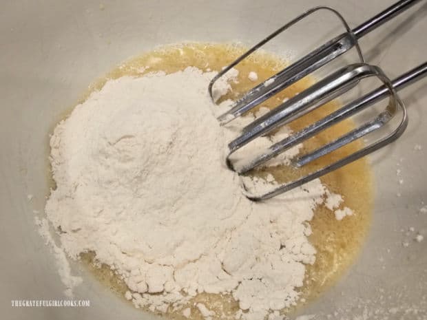 All-purpose flour is beaten into the yeast mixture in the bowl.