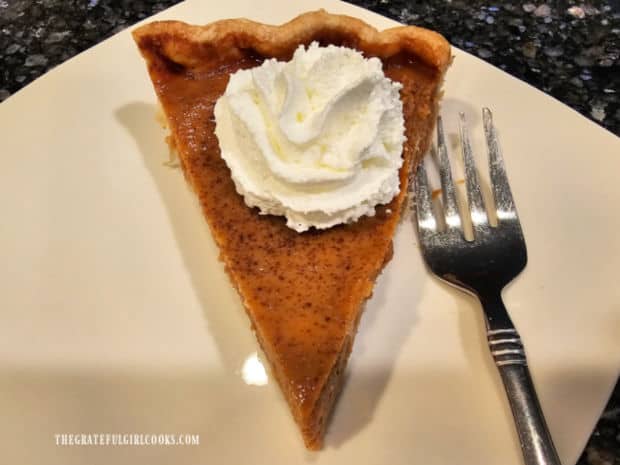 Classic Pumpkin Pie - The Grateful Girl Cooks! A piece of classic pumpkin pie, topped with whipped cream for serving.